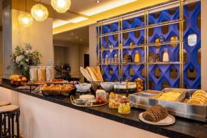 Una línea de buffet con muchos tipos diferentes de comida. en Hotel Le Rocroy, en París