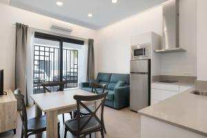 Il comprend une cuisine et un salon avec une table et des chaises. dans l'établissement Apartamento Virgen de la Luz 4, à Conil de la Frontera