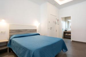 a bedroom with a blue bed and a bathroom at Apartamento Virgen de la Luz 4 in Conil de la Frontera