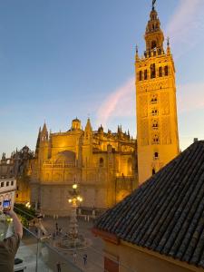 osoba robiąca zdjęcie budynku z wieżą zegarową w obiekcie An Indian Bollywood Sevilla Experience - for families, couples & business trips w Sewilli