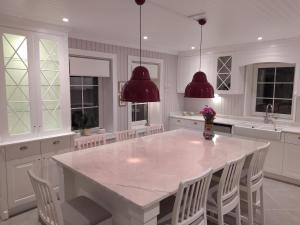 a white kitchen with a large white table and chairs at Villa Ladybug Unique design of your dreams in Foca