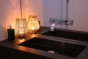 a bathroom with a sink and two vases on a counter at Bed & Wellness Boxtel in Boxtel