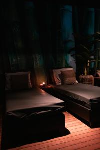 Bed & Wellness Boxtel في بوكستيل: سريرين في غرفة مظلمة وبها شمعة