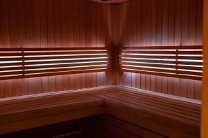 uma sauna com painéis de madeira e luz solar a brilhar através das janelas em Bed & Wellness Boxtel em Boxtel
