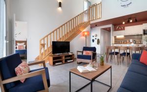 a living room with blue furniture and a staircase at Pierre & Vacances Premium Les Villas d'Olonne in Les Sables-d'Olonne