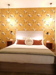 a bedroom with a large bed with a yellow wall at APARTAMENTO CALMA in Logroño
