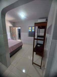 Un dormitorio con una cama y una escalera. en Suítes good trip itacare en Itacaré