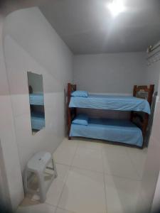 a small room with two bunk beds and a stool at Suítes good trip itacare in Itacaré