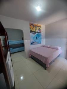 um quarto com uma cama e um cartaz na parede em Suítes good trip itacare em Itacaré