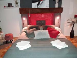 a bedroom with a bed with pillows and a fireplace at VILLA DEL PARCO in Mesnil-la-Comtesse