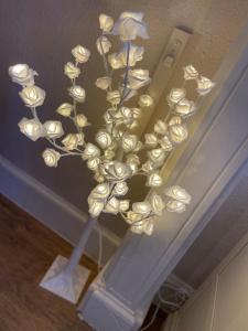 una lámpara de araña con flores blancas en el techo en Abbey House B & B, en Penrith