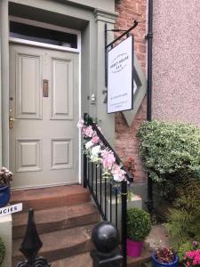 Una puerta a una casa con un cartel. en Abbey House B & B, en Penrith