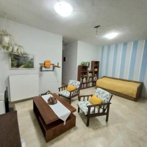 salon z 3 krzesłami i łóżkiem w obiekcie PUZZLE SWEET HOME w mieście Seres