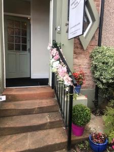 una casa con flores en el porche delantero en Abbey House B & B, en Penrith