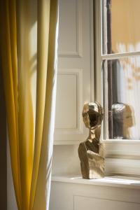 a statue sitting in a window next to a curtain at Casa G. Firenze in Florence
