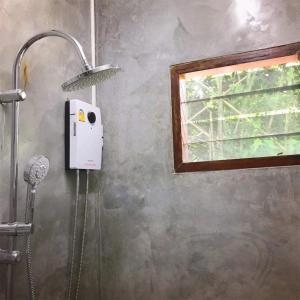a shower in a bathroom with a window at BaanNakanoHomestay in Mae Rim