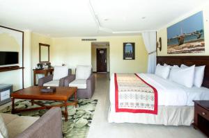 a hotel room with a large bed and a couch at PrideInn Paradise Beach Resort & Spa Mombasa in Mombasa