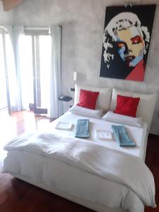 a bedroom with a large white bed with red pillows at Il giardino di Pietro in Monza