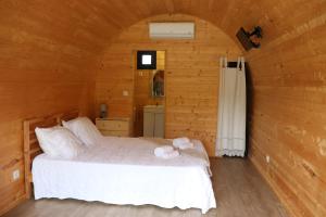 - une chambre avec un lit dans une pièce en bois dans l'établissement Outeiro do Moinho, à Campo do Gerês