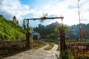 a path in a garden with a wooden gate at Thanh Truc Villa & Flower in Sa Pa