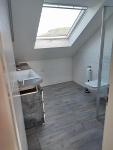 a bathroom with a skylight and a sink and a toilet at Urlaub schwäbische Albkante 