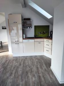 a kitchen with white cabinets and wood floors at Urlaub schwäbische Albkante 