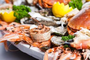 ein Berg Meeresfrüchte auf einem Teller mit einem Sandwich in der Unterkunft Le Penty de Nalzu in Saint-Yvy + 4 Fotos