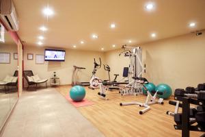 a gym with exercise equipment and a flat screen tv at Giannoulis - Santa Marina Plaza (Adults Only) in Agia Marina Nea Kydonias