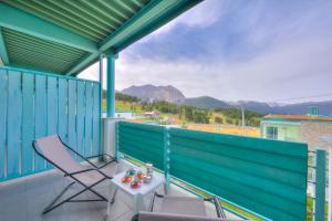 a balcony with a table and chairs and mountains at Teleo 50mt From Ski Apartments - Happy Rentals in Sestriere