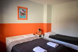 a bedroom with two beds and an orange and white wall at Cinerama Hostel in San Carlos de Bariloche