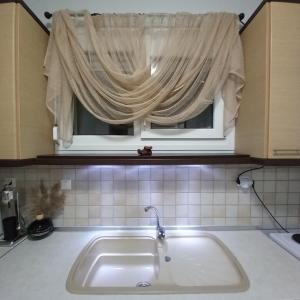 a sink in a kitchen with a window at PUZZLE SWEET HOME in Serres +31 photos