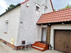 a white house with a table and chairs in front of it at PRIMEX tani nocleg in Poznań