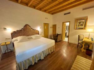 a bedroom with a bed and a desk in a room at Las Casas de la Judería de Córdoba in Córdoba