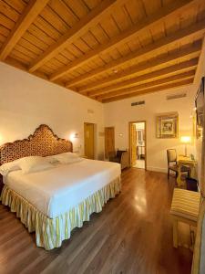 1 dormitorio con 1 cama grande y suelo de madera en Las Casas de la Judería de Córdoba, en Córdoba