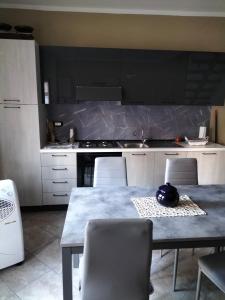 eine Küche mit einem Tisch, Stühlen und einer Theke in der Unterkunft Borghetto Verde in Locri