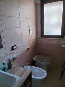 a bathroom with a toilet and a sink and a window at Borghetto Verde in Locri