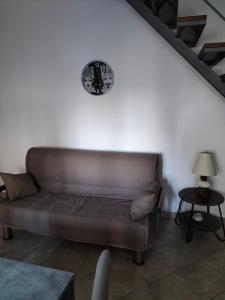 a couch in a living room with a clock on the wall at Borghetto Verde in Locri