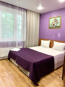 モスクワにあるHotel Bonjour Butovoの紫の壁のベッドルーム1室(大型ベッド1台付)