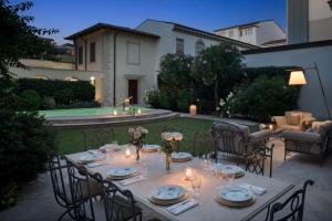 einen Tisch mit Gläsern und Tellern auf einem Hinterhof in der Unterkunft Luxury Villa Manin Viareggio | UNA Esperienze in Viareggio