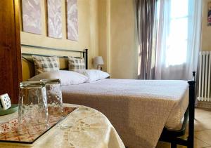 Un dormitorio con una cama y una mesa con una bandeja de cristal en Cascina Foresto, en Cossato