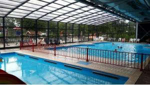a large swimming pool with a large glass wall at Chalet Eben Haëzer in Rheezerveen