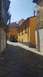 een steegje met gele gebouwen en een auto op straat bij Janara - Arco di Traiano in Benevento