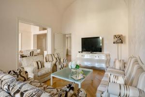 ein Wohnzimmer mit einem Sofa und einem Tisch in der Unterkunft Luxury Villa Manin Viareggio | UNA Esperienze in Viareggio