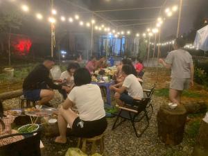 een groep mensen die aan een tafel onder een tent zitten bij Thanh Truc Villa & Flower in Sa Pa