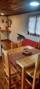 a table and chairs with a couch in a room at Cabaña del Antiguo Poblador in Ushuaia
