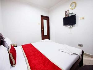 a bedroom with a bed and a tv on the wall at Sitara Paradise in Hyderabad
