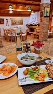 einem Holztisch mit Teller mit Lebensmitteln darauf in der Unterkunft Hotel Dollari in Durrës