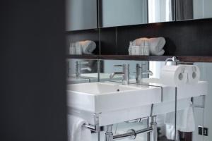 ein Badezimmer mit 2 Waschbecken, einem Spiegel und Handtüchern in der Unterkunft Buckingham Palace Mansion - Sleeps 12 in London
