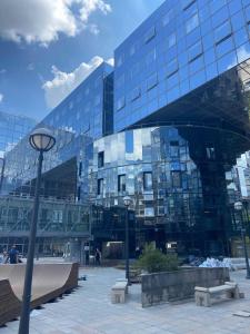 un grand bâtiment en verre avec des bancs devant lui dans l'établissement Ecla Paris Noisy-le-Grand, à Noisy-le-Grand