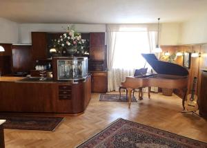 a living room with a grand piano and a fish tank at Hotel Adler in Sankt Georgen im Schwarzwald